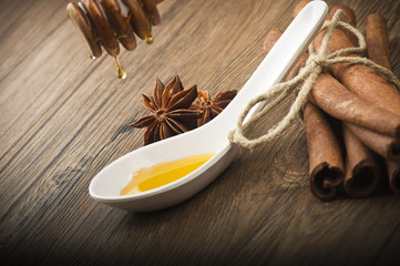 wooden honey dipper and spices on wood table