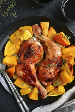 Chicken legs baked with pumpkin and orange.Top view.