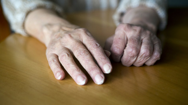closeup of old female hands on table