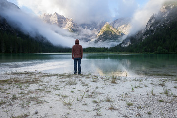 Fototapeta na wymiar Man standing near mountain lake