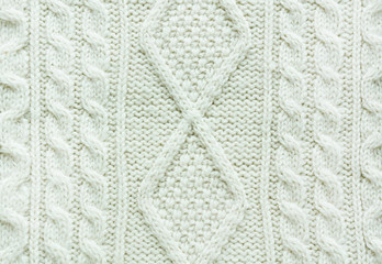 Texture of knitted handmade. Christmas white sweater close up. Wallpaper or abstract background.