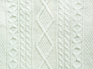 Texture of knitted handmade. Christmas white sweater close up. Wallpaper or abstract background.