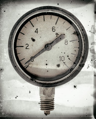 The old vintage measuring device with a scale from 0 to 10, and the arrow is stuck at zero. Stylised as aged old b&w photos. Industrial background.