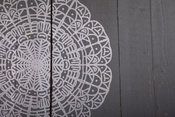 White mandala on dark wooden background