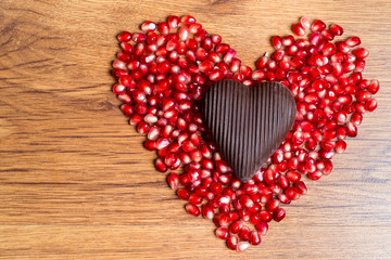 Heart of red pomegranate seeds and dark chocolate - a declaration of love on Valentine's Day.