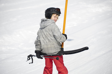 Child boy skiing in mountains. Active teenager kid with safety helmet and goggles. Ski race for young children. Winter sport for family. Kids ski lesson in alpine school. Young skier racing in snow