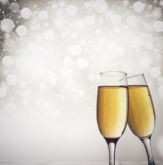 champagne glasses against holiday lights