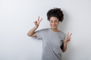 Happy woman making the victory symbol with both hands