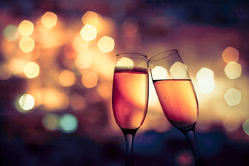 champagne glasses against holiday lights
