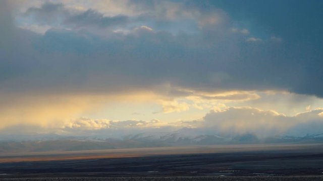 Mountain steppes of Mongolia. On the barren landscape of mountain steppes of Mongolia seen the first snow-capped peaks of the coming winter. Timelapse