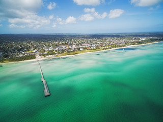 Aerial view of Rosebud pier and coastline featuring vivid turquoise bay water. Mornington Peninsula, Melbourne, Australia