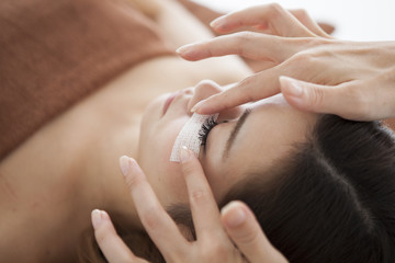 The woman is extending her eyelash with a salon