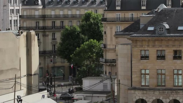 Busy city streets of Paris with camera tilting up to reveal the iconic Eiffel Tower. Filmed in the summertime on a sunny day