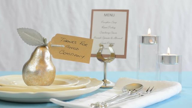 Elegant Happy Thanksgiving place setting with gold pear, candles and menu, with focus on pear with Thanks for Good Company card, static.