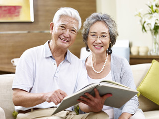 senior asian couple reading a book together