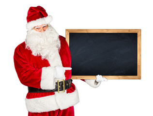 Santa claus holding empty blackboard with wooden frame and pointing with his finger on it isolated...