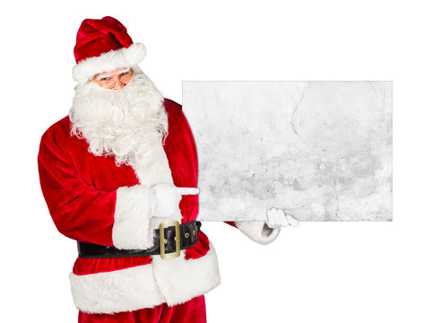 Santa claus holding empty concrete billboard and pointing with his finger on it isolated on white background / weihnachtsmann nikolaus mit leerer Werbetafel isoliert