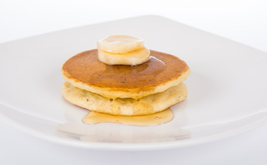 honey dripping on the cake and banana in plate