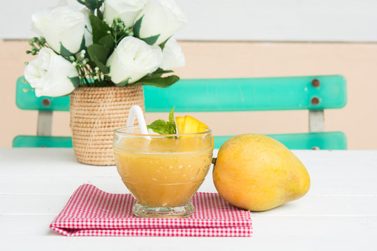 Mango juice in glass on table cloth and mango fruit