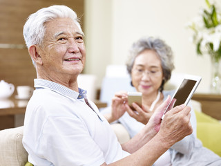 senior asian couple enjoying modern technology