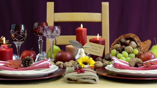 Traditional Thanksgiving table with place settings and cornucopia centerpiece in colorful rustic style, dolly reveal full table.