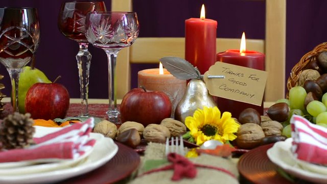 Traditional Thanksgiving table with place settings and cornucopia centerpiece in colorful rustic style, dolly reveal closeup.