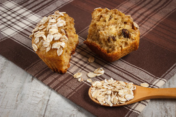 Fresh muffin with oatmeal baked with wholemeal flour on checkered tablecloth, delicious healthy dessert