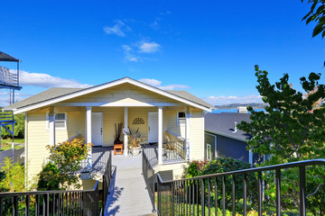 American yellow duplex house on blue sky background.