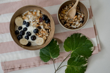 brunch : home made yogurt with granola and banana in wooden bowl.