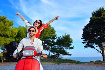 Beautiful young couple in love enjoying and having fun riding on a scooter © FS-Stock