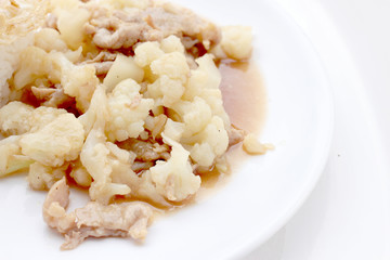 Fried cauliflower with pork, fried eggs with rice in white dish isolate on white background, Thai style food