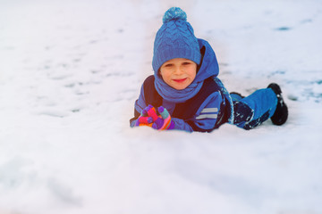 Fototapeta na wymiar happy little boy having fun in winter snow