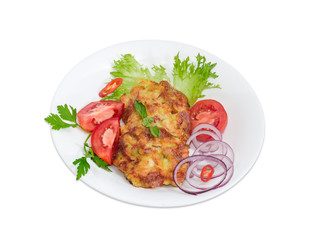Chopped cutlets and vegetables on white dish on light background