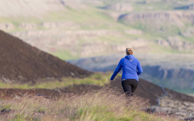 Fototapeta na wymiar Shot of a young woman hiking in Iceland