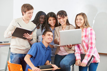 Lehrer und Gruppe Schüler mit Laptop