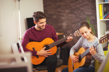 Guitar teacher teaching the little girl