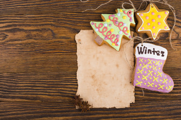Christmas background with copy space. Gingerbread cookies hanging over wooden background. Christmas decorations top view with copy space. Prepare for xmas eve or other winter holidays