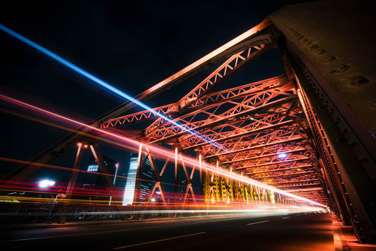 Traffic on red steel bridge at night