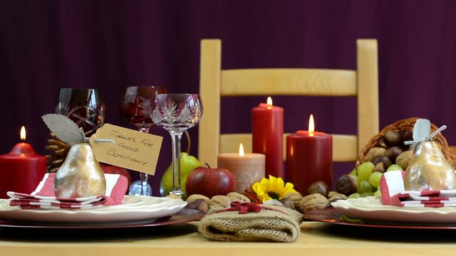 Traditional Thanksgiving table with place settings and cornucopia centerpiece in colorful rustic style, static front focus.