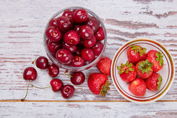 Cherry in glass jar on and Strawberry on plate rustic table