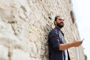 man with smartphone at stone wall