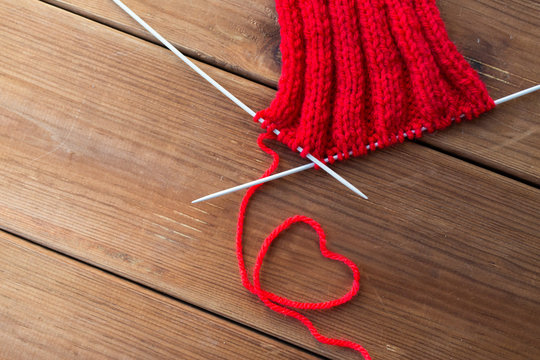 Knitting Needles And Thread In Heart Shape On Wood