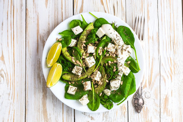 Salad with avocado, feta cheese, spinach, lime and spices