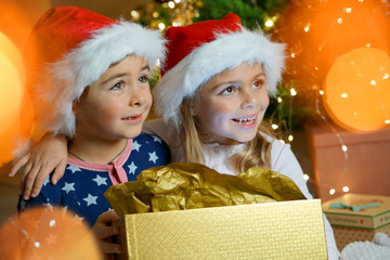 Cute children on Christmas day looking at tree