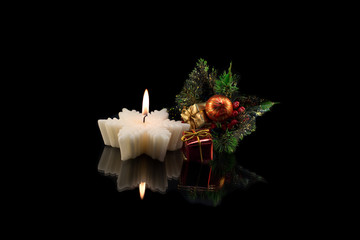 The branch of a Christmas tree with gifts, toys and candle