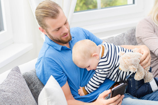 Vater mit Handy und Sohn