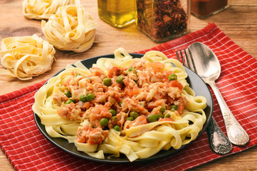 Pappardelle pasta with minced meat, green peas, tomatoes and cheese.