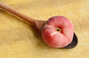 Dough nut peaches also known as Saturn peach withwooden spoon on wooden board.
Benefits of Dough...