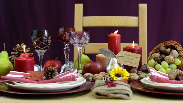 Traditional Thanksgiving table with place settings and cornucopia centerpiece in colorful rustic style. static full table mid focus.