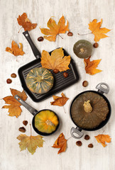 Pans with pumpkins and autumn leaves